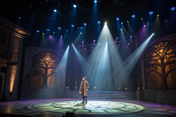 Actor on a decorated stage with spotlights, dramatic theater performance setting